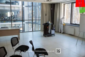 Professional deep cleaning services for offices, with a worker sanitising windows in protective gear in Manchester Wigan St Helens Bolton